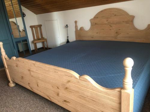 a wooden bed with a wooden frame in a bedroom at Haus Bross in Hayingen