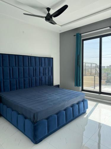 a blue bed in a bedroom with a ceiling fan at Superior Villa in Mirpur city Azad kashmir 