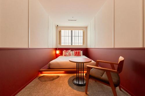 京都的住宿－京都塔酒店，卧室配有1张床、1张桌子和1把椅子