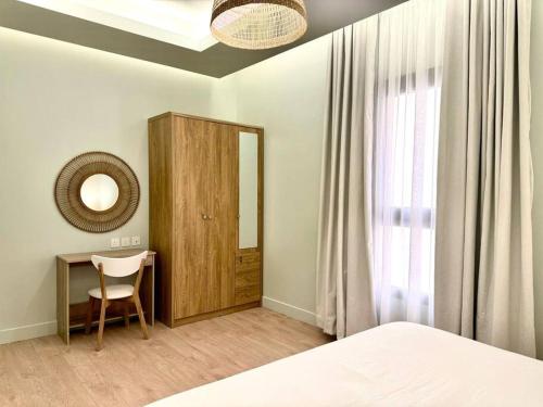 una camera con letto, scrivania e specchio di Aurora Residence - شقة أورورا a Riyad