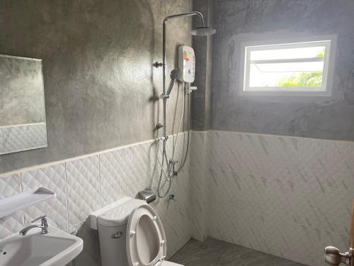a bathroom with a shower and a toilet and a sink at จอมเมือง Motel in Nan