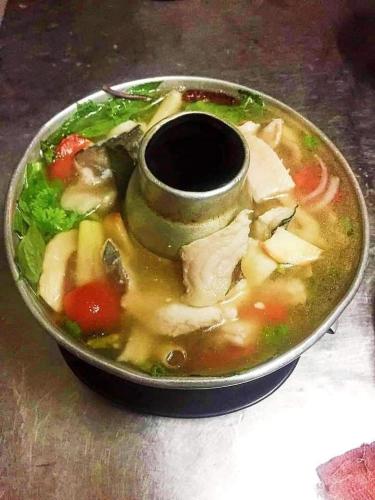 a bowl of soup with meat and vegetables at จอมเมือง Motel in Nan
