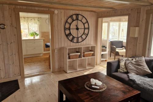 a living room with a large clock on the wall at Trevliga stugor i Torhamn, perfekt för familjer in Karlskrona
