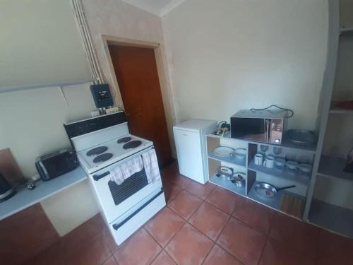 a kitchen with a stove and a refrigerator at A humble abode that is cozy in Centurion