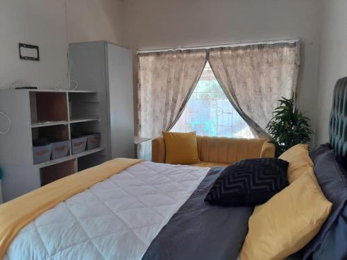 a bedroom with a large bed and a window at A humble abode that is cozy in Centurion