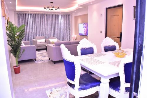 ein Esszimmer mit einem weißen Tisch und blauen Stühlen in der Unterkunft El ma Furnished Apartment in Nairobi