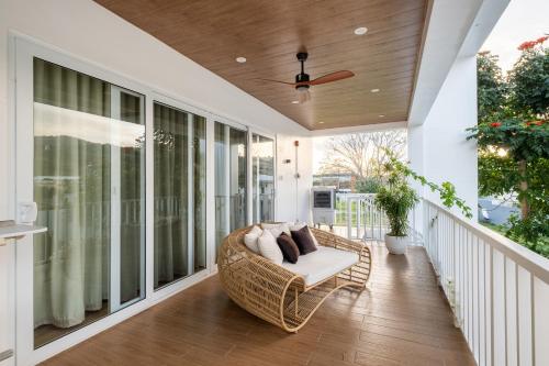 a porch with a wicker chair on a balcony at Tirta Spring Villa with Hotspring Pool in Los Baños
