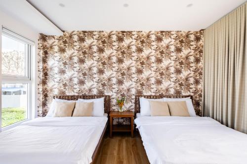 two beds sitting next to each other in a bedroom at Tirta Spring Villa with Hotspring Pool in Los Baños