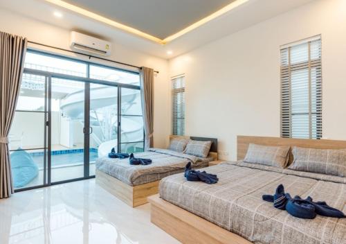 Ban Bo Fai (1)的住宿－Melancia Pool Villa Hua-Hin，带阳台的卧室内的两张床