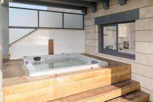 a jacuzzi tub in a room with a large window at Jacuzzi Penthouse with wide Sea View in Natanya in Netanya