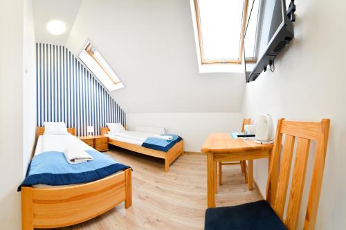 een kleine kamer met 2 bedden en een tafel bij Marina Grudziądz in Grudziądz