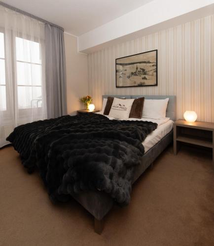 a bedroom with a large bed with a black blanket at Alpejski Zieleniec in Duszniki Zdrój