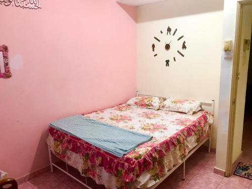 芙蓉的住宿－Isyfaq Homestay 4 Bedroom & 3 Bathroom，小卧室配有一张挂在墙上的带时钟的床