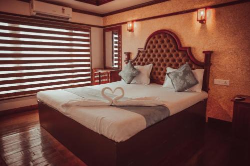 Schlafzimmer mit einem Bett mit Herzdekoration in der Unterkunft Victoria Houseboats in Alappuzha