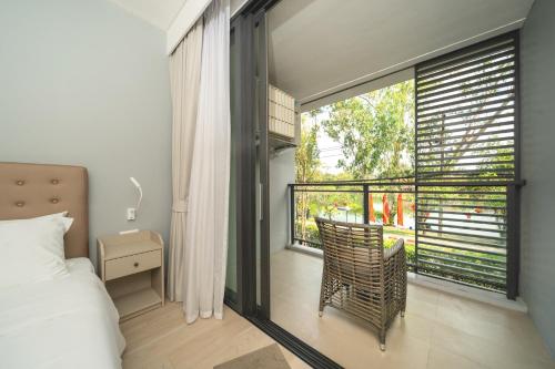 1 dormitorio con 1 cama y balcón con ventana en Лагуна Пхукет Апартаменты 2 спальни 300 метров до пляжа Бангтао, en Phuket