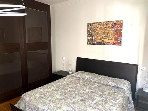 a bedroom with a bed and a painting on the wall at Villa Senagra Holidays Lake Como in Menaggio