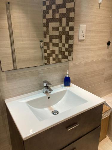 lavabo blanco en el baño con espejo en Side SeaView 3Bedrooms Apartment Sliema steps from Promenade and Sliema Ferry, en Sliema
