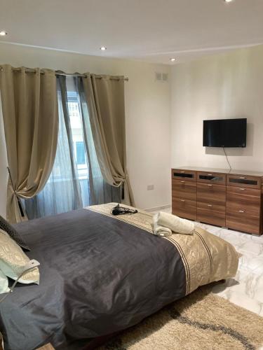 a bedroom with a large bed and a flat screen tv at Side SeaView 3Bedrooms Apartment Sliema steps from Promenade and Sliema Ferry in Sliema