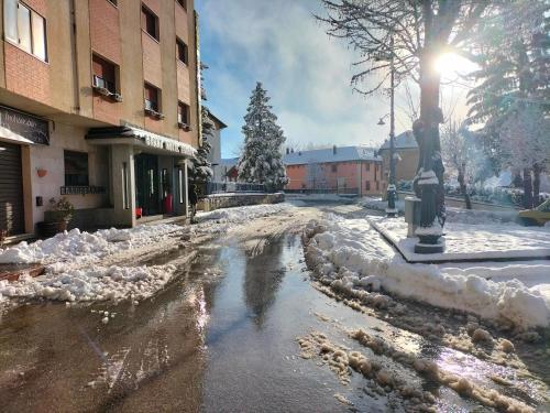 a street covered in snow next to a building at Grand Hotel Europa Rivisondoli Centro in Rivisondoli