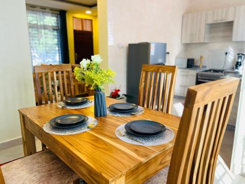 a wooden table with chairs and a dining room at Oaklands Apartments in Morogoro