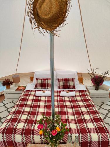 a bed with two pillows and flowers on it at Puszcza Glamping in Kuraszewo