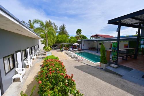 a resort with a pool and chairs and a building at Samui Backpacker Hotel in Bangrak Beach