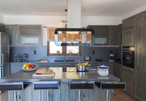 a kitchen with wooden cabinets and a counter with fruit on it at Villa Kallisto in Nydri