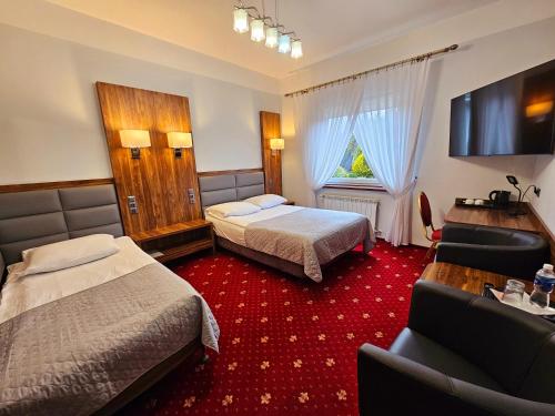 a hotel room with two beds and a television at Hotel Hawana in Bydgoszcz