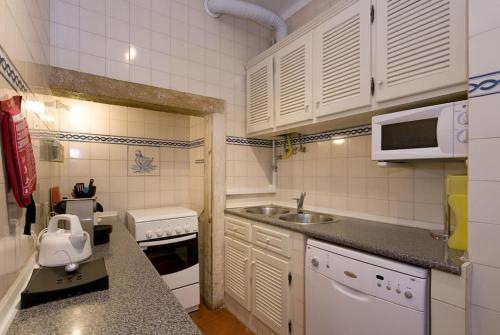 uma pequena cozinha com um lavatório e um micro-ondas em PN STYLISH & CENTRAL- view to tram 28! em Lisboa