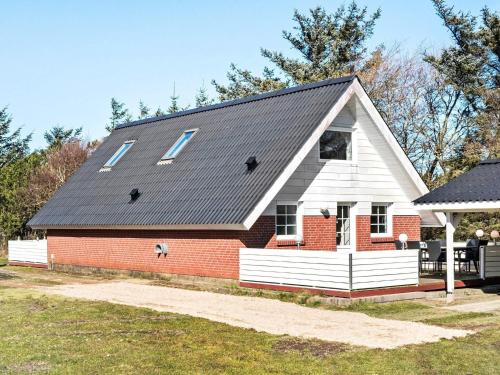 スナーヴィグにある6 person holiday home in Ringk bingの赤レンガ造りの黒屋根