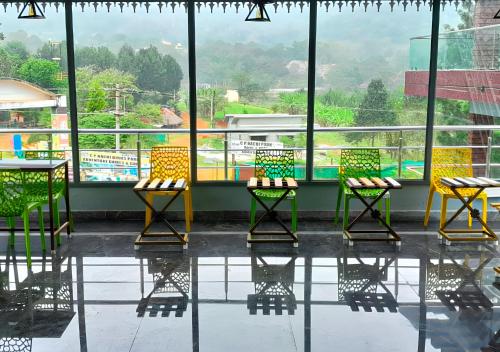 a group of chairs sitting in front of a window at Yelagiri GoldHill Resort in Yelagiri