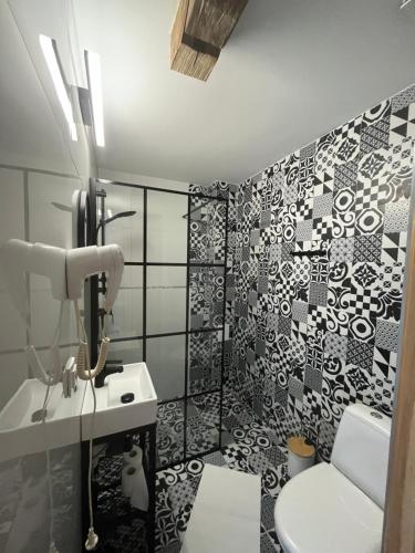 a bathroom with a black and white patterned wall at Słoneczny Wodnik in Braniewo