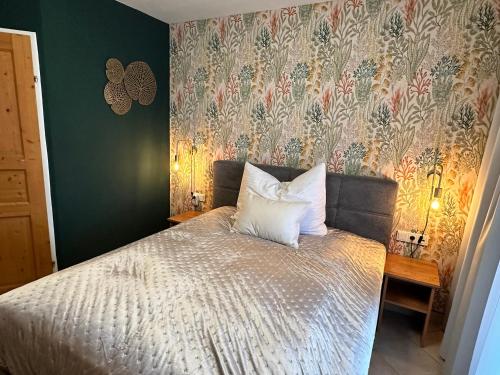 1 dormitorio con 1 cama y papel pintado con motivos florales en Brauner Bär, en Altenberg