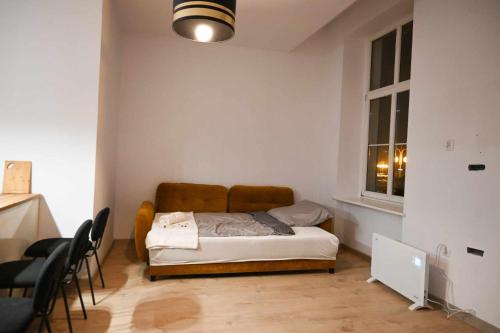 ein Schlafzimmer mit einem Bett in einem Zimmer mit einem Fenster in der Unterkunft Apartament w Centrum Kalisza in Kalisz