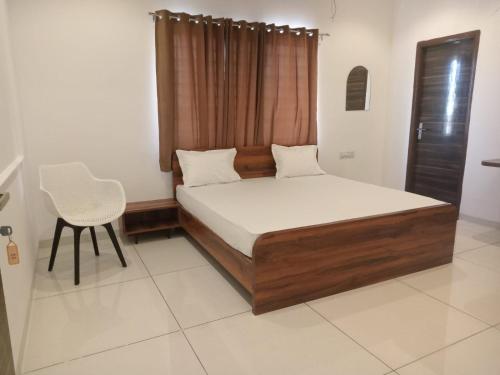 - une chambre avec un lit et une chaise dans l'établissement Vaatsaly Rooms, à Indore