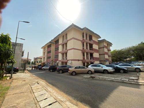 um parque de estacionamento com carros estacionados em frente a um edifício em Gimbiya street NNPC estate em Abuja