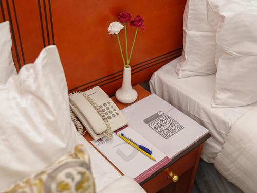 a table with a book and a vase with flowers at Diyar Al Deafah Hotel in Mecca
