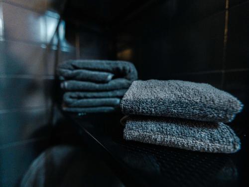 four towels are stacked on a glass shelf at Elegante a due passi dal mare in Alassio