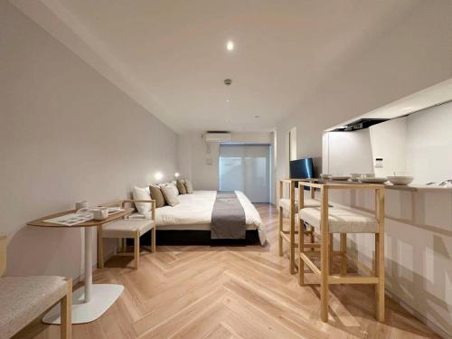 広島市にあるbHOTEL Rijodori - Complimentary Breakfast Included, City Central Studioのベッドとテーブルとキッチンのある寝室