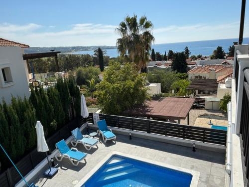 a swimming pool with chairs and a view of the ocean at Villa Marina Sea-View Private Pool in Peyia