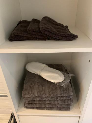 dwie półki szafy z ręcznikami w obiekcie Maisonette tout confort w mieście Le Thillay