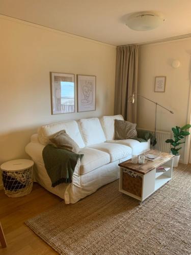 a living room with a white couch and a table at Strandlägenhet Byxelkrok, Öland in Byxelkrok