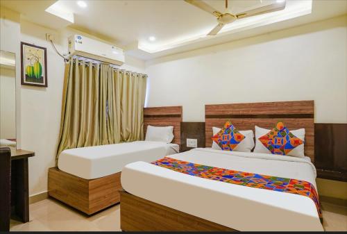 una camera d'albergo con due letti e una finestra di Hotel Raj vihar residency a Vijayawāda