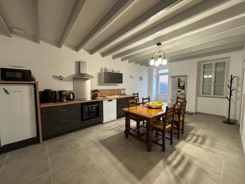 cocina con mesa y sillas en una habitación en L’ÉCURIE, en Gigny