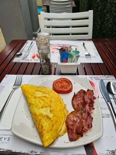 a plate of breakfast food with a omelet and meat at 4 on Varneys Guest House in Cape Town