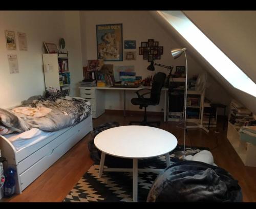 une chambre avec un lit, une table et un bureau dans l'établissement Saint germain, à Poissy