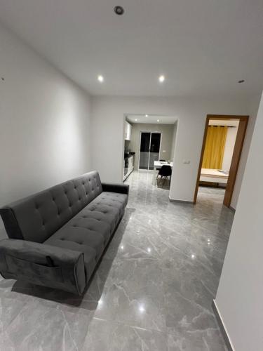 a living room with a leather couch in the middle at Brand new apartment in Mindelo in Mindelo