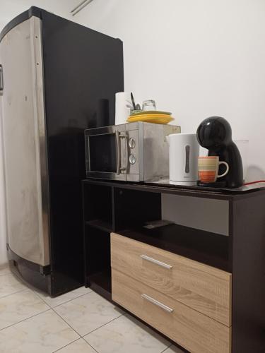 una estantería negra con un microondas encima en camera cu baie, en Timisoara