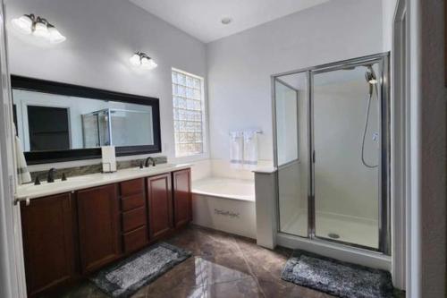a bathroom with a shower and a sink and a tub at Cozy Latitude home with pool in Goodyear