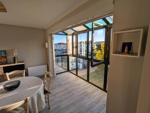 Cette chambre comprend un lit et une grande fenêtre. dans l'établissement Appartement plein coeur Port Olona, à La Chaume